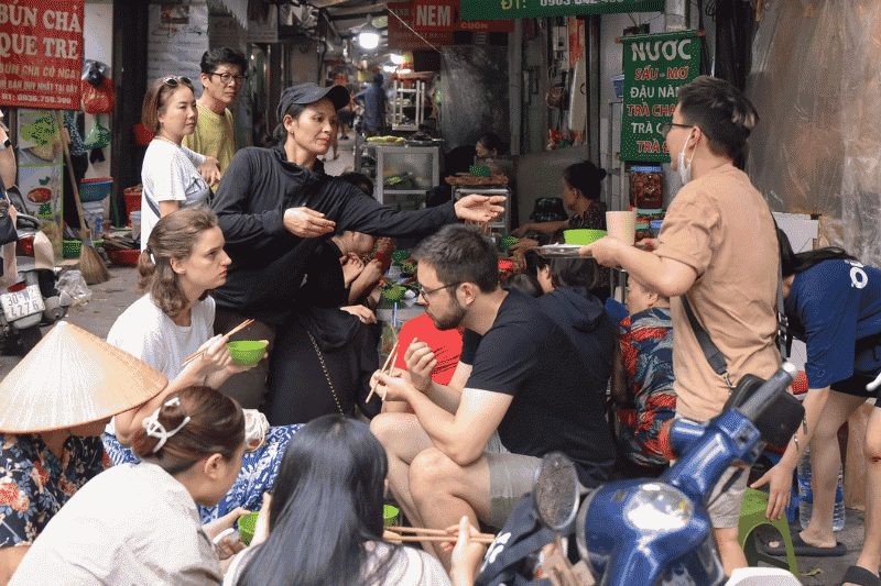Reisende genießen das Streetfood in Vietnam (Quelle: Vietnam.VN)